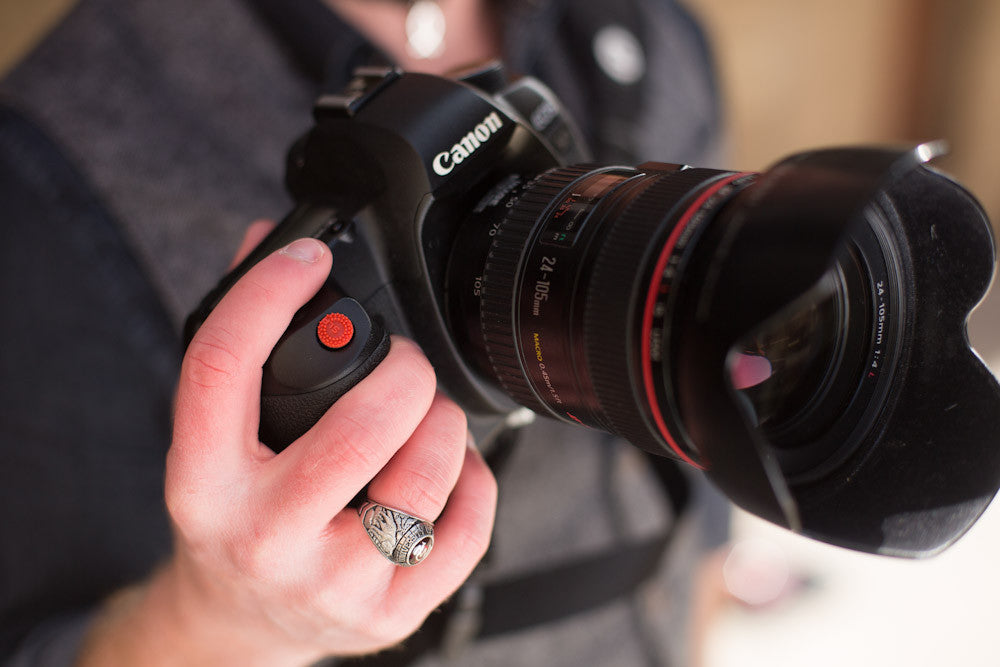 Closeup of hand on DSLR camera with ProDot Shutter Button Upgrade